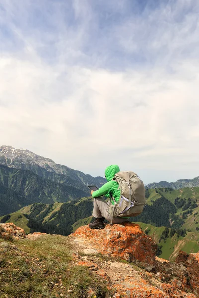 Backpacker sitting on mountain peak