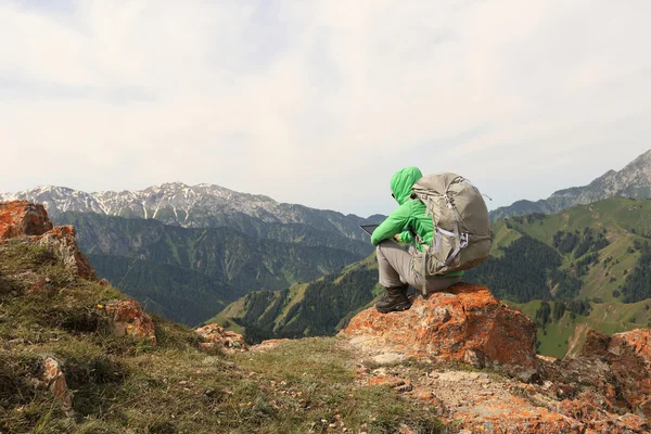 Backpacker sitting on mountain peak