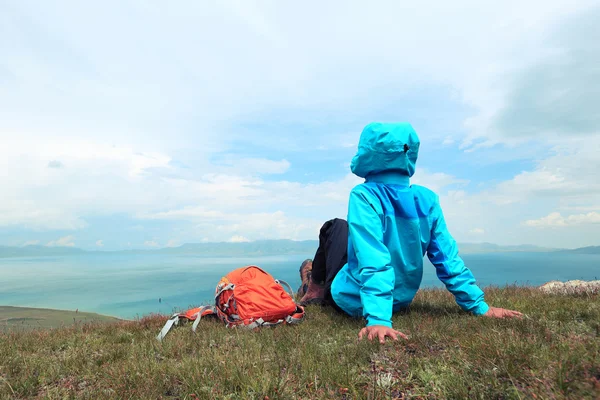 Backpacker sitting on mountain peak