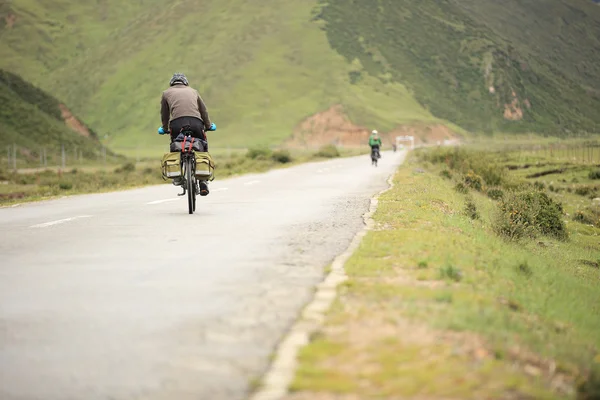 Mountain bike rides along the asphalt road in the high mountains of tibet, china