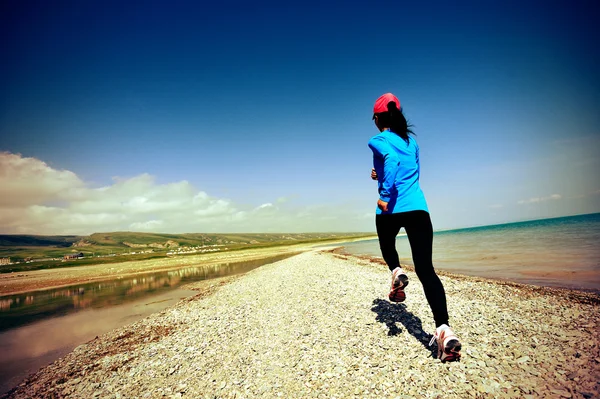 Runner athlete running on stone beach of qinghai lake