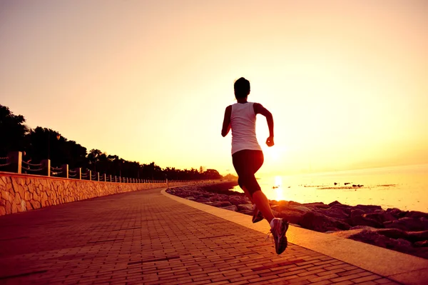 Runner athlete running at seaside. woman fitness silhouette sunrise jogging workout wellness concept.