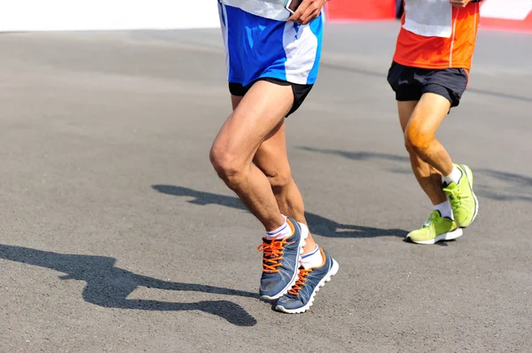 Marathon runner legs running on city road