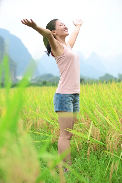 Young asian woman open arms at paddy field