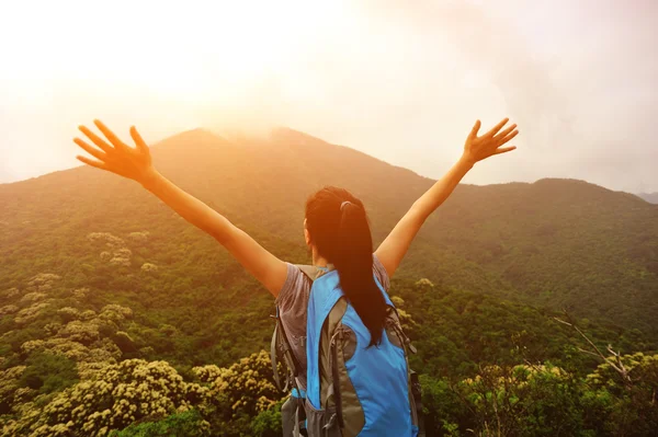 Woman with open arms at sunset