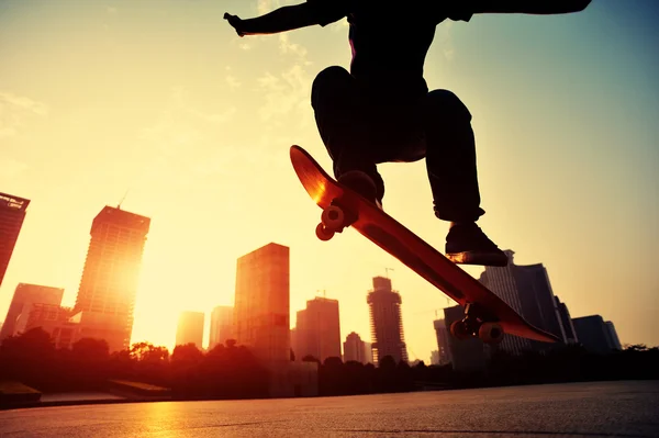 Skateboarder over sunrise city