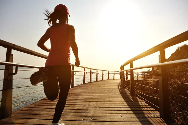 Healthy woman running on boardwalk