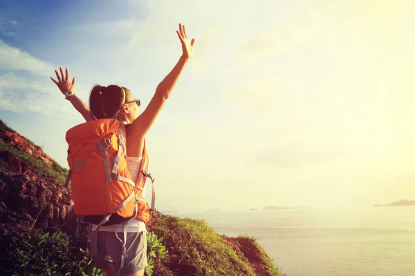 Cheering woman over seaside mountain