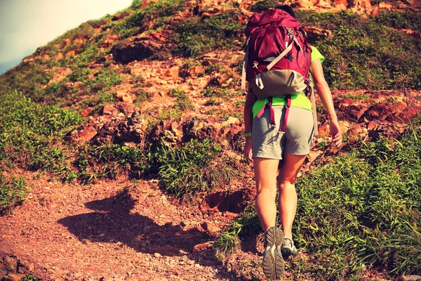 Woman backpacker climbing on