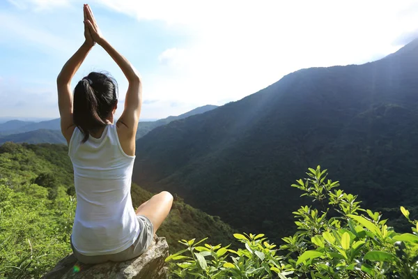 Yoga woman meditating on mountain