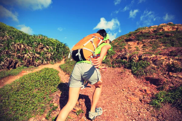 Woman backpacker running on mountain