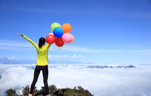 Cheering woman with colorful balloons