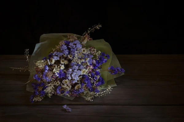 Bouquet of dried flower on wooden background.