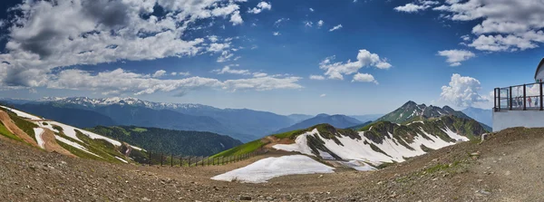 Russia, Sochi, 21 June 2016: Summer Panorama of mountains from Roza Pik 2320, an observation deck, the top point of ski slopes on Krasnaya Polyana to Sochi, the snow remains on slopes, stones, snow
