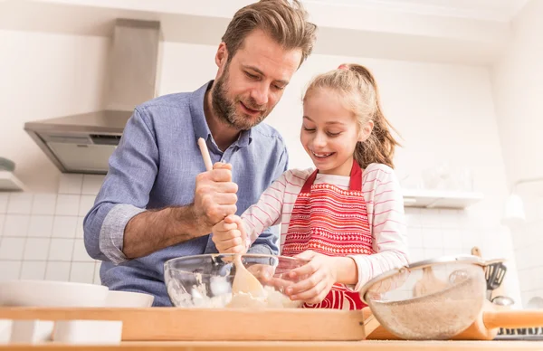 Father and daughter preparing cookie dough in the kitchen