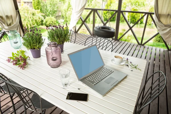 Laptop computer and mobile phone (smartphone) in the garden