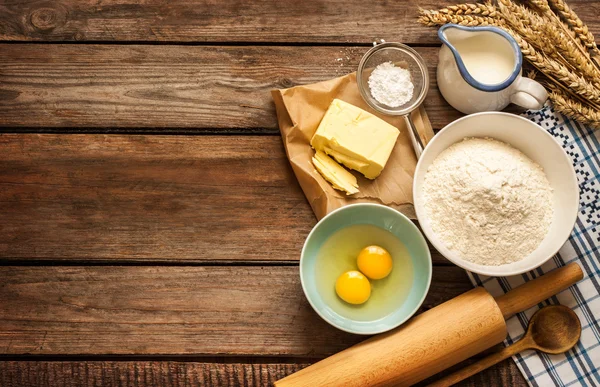 Baking cake in rural kitchen - dough recipe ingredients on wood