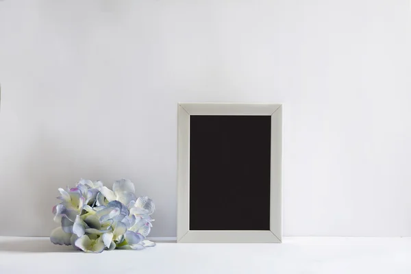 Empty picture frame, decorated with blueflowers