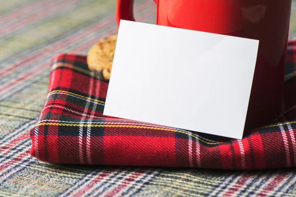 Coffee cup and business card, plaid blanket red
