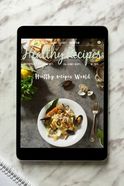 Tablet With healthy recipes blog on screen. web with nutritious