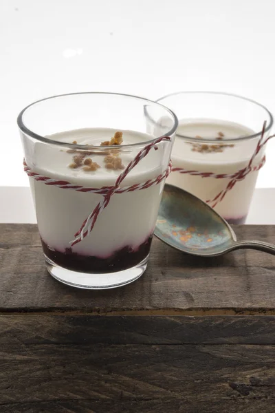 Layered dessert with fruits yogurt and cream cheese in glass jar
