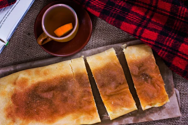 Tea, plaid, cake and a book.