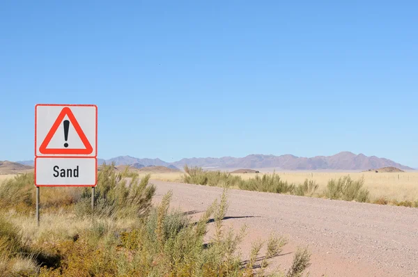 Sand in road warning sign
