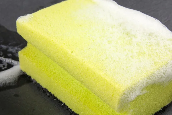Cleaning soapy sponge with scrub isolated on black background