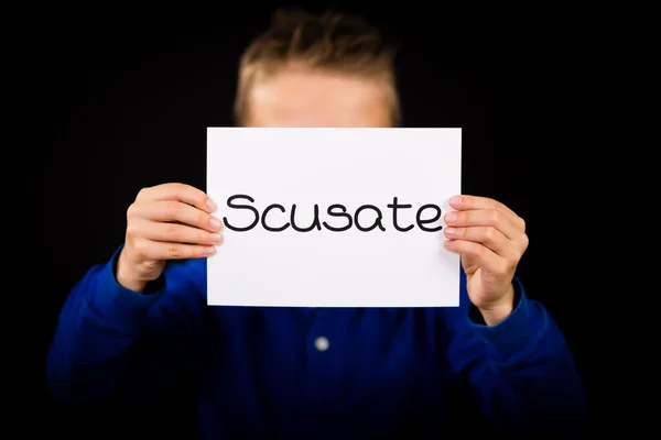 Child holding sign with Italian word Scusate - Sorry