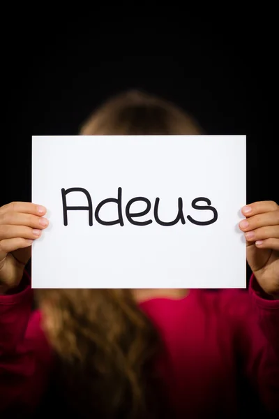 Child holding sign with Portuguese word Adeus - Goodbye