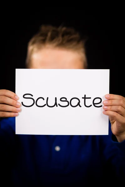Child holding sign with Italian word Scusate - Sorry