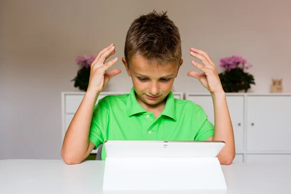 Frustrated boy using white tablet
