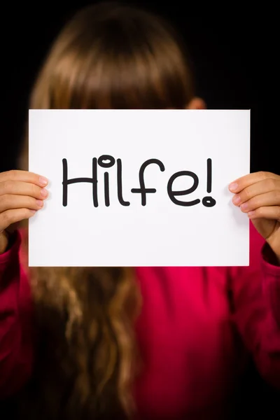 Child holding sign with German word Hilfe - Help