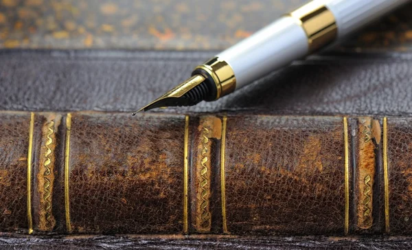Fountain pen with a gold pen lying on old book, shallow DOF