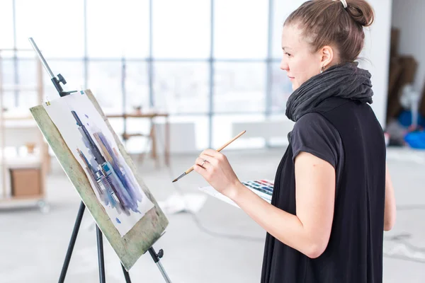 Female painter drawing in art studio