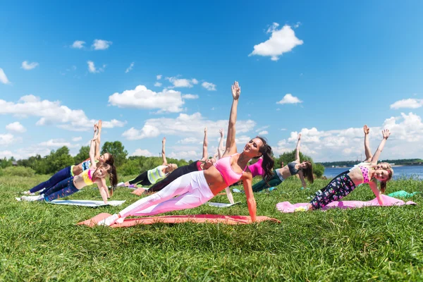 Group of fit girls going side plank