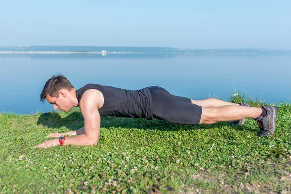 Fit man doing plank core exercise