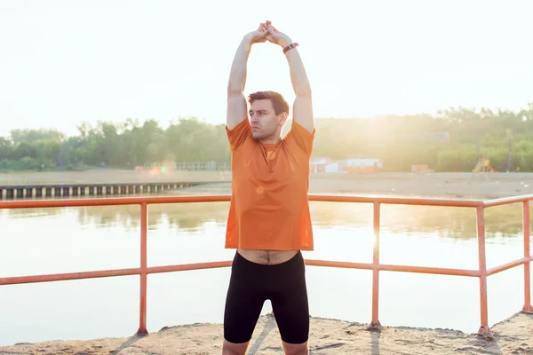 Fit man athlete doing arm stretches