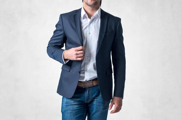 Man in trendy suit  standing alone holding his jacket with confidence