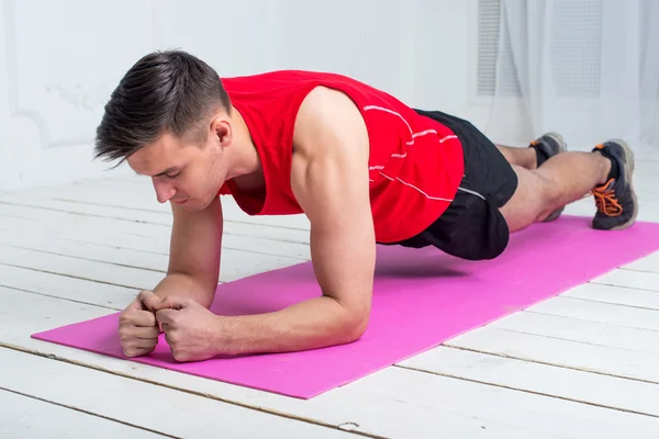 Fitness training athletic sporty man doing plank exercise in gym or home concept exercising workout aerobic