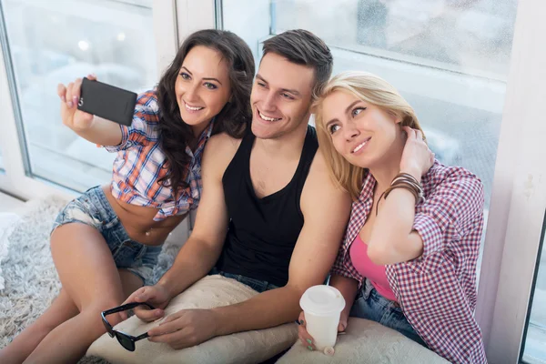 Happy friends two women and man taking selfie with camera or smartphone together wearing summer clothes  jeans shorts jeanswear street urban casual style having fun.