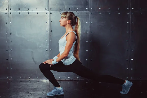 Athlete woman stretching legs in gym doing fitness exercise concept sport training.