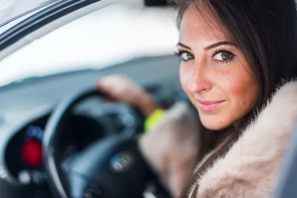 Woman car driver in fur coat.