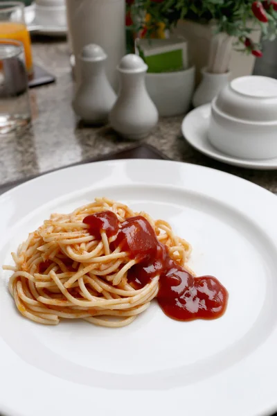 Spaghetti with tomato sauce on white dish.