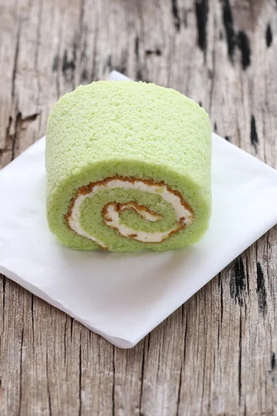 Roll cakes jam flavor pandan leaves on white paper.