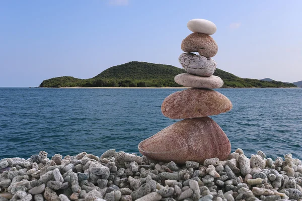 Balance stone on pile rock of sea background.