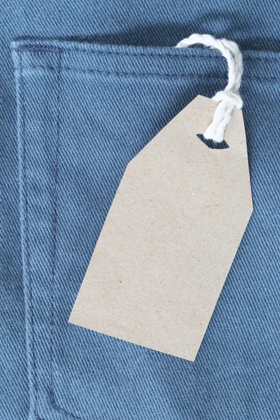 Brown paper label with hemp rope tied on denim or jeans.