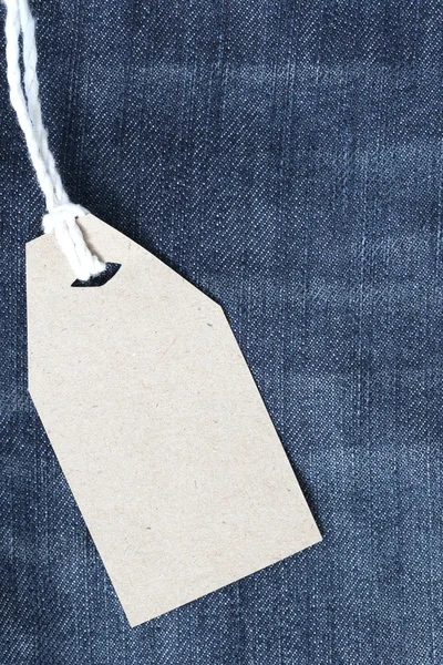 Brown paper label with hemp rope tied on denim or jeans.