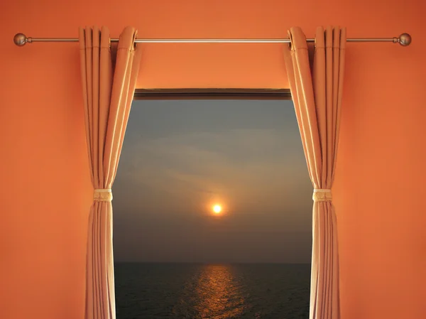 Orange room have a window with blinds you can see sunset in even