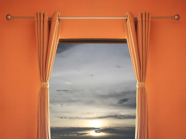 Orange room have a window with blinds you can see sunset in even